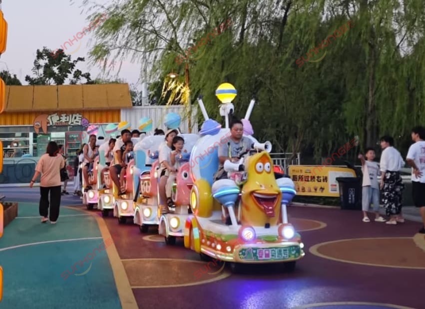 sunhong-Larva-themed-amusement-park-train-ride-passengers People riding a colorful SUNHONG Larva-themed amusement park train ride, designed for theme park entertainment and family-friendly amusement attractions