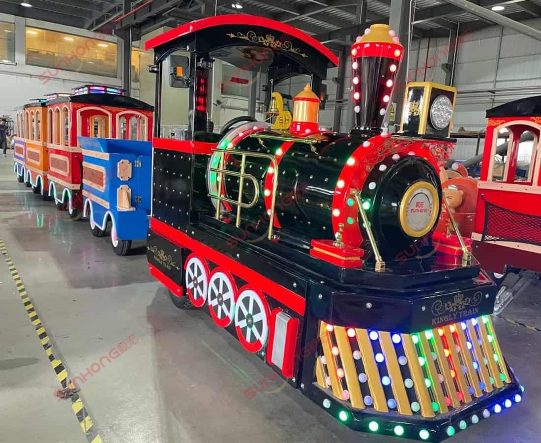 Colorful amusement park trackless train with LED lights, black, red, and gold. Colorful trackless electric train ride with LED lights in black, red, and gold design for amusement park use.
