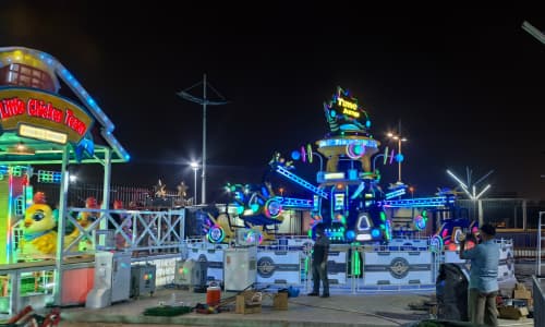 Engenheiros da SUNHONG instalando e testando o Time Jump e uma mini montanha-russa em um parque de diversões no Kuwait à noite - SUNHONG
