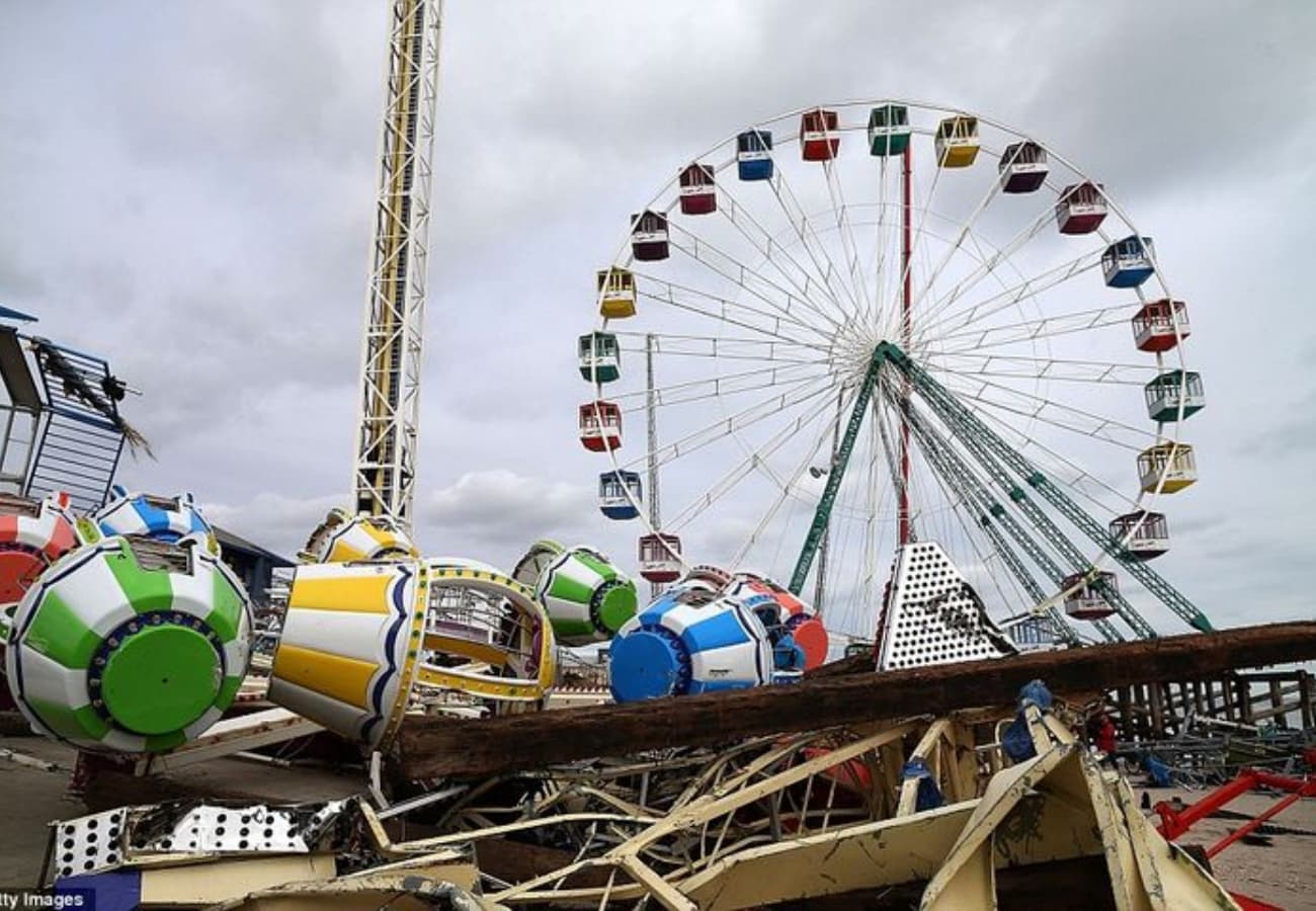 Severe amusement park ride malfunction with collapsed gondolas and damaged Ferris wheel structure after failure