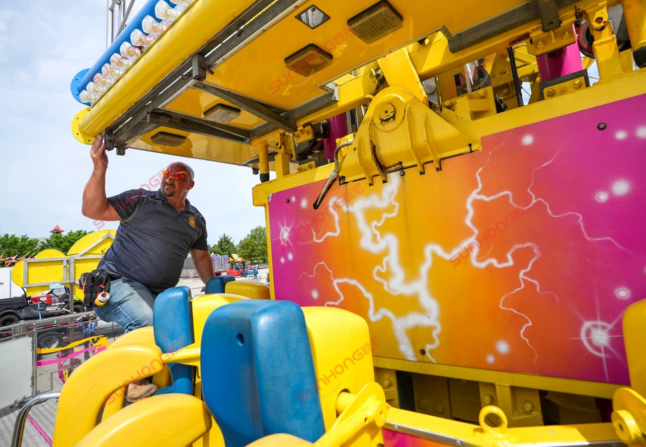amusement-ride-inspection-checklist-inspector-examining-drop-tower.jpg - SUNHONG Amusement ride inspector examining drop tower ride mechanism as part of regular inspection checklist - SUNHONG