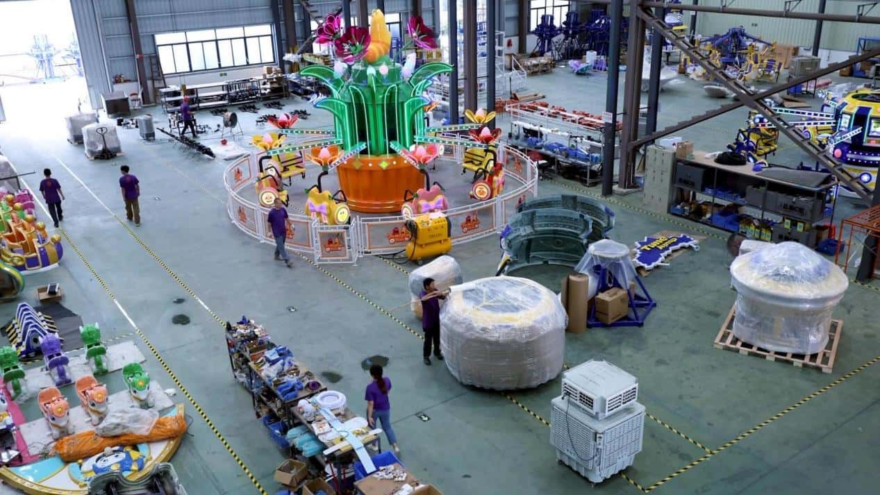 Factory view of amusement ride manufacturer showcasing Larva Blooms plane ride and ride components in production - SUNHONG