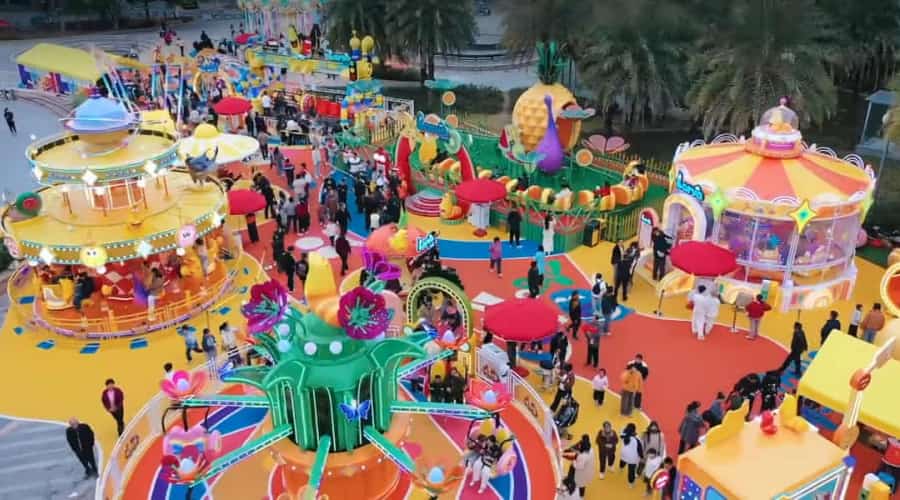 Parque temático Larva no centro da cidade, projetado e construído pela SUNHONG, com Larva Blooms no canto inferior esquerdo, carrossel à esquerda e mini montanha-russa e brinquedos de tiro ao alvo com bolas acima - SUNHONG