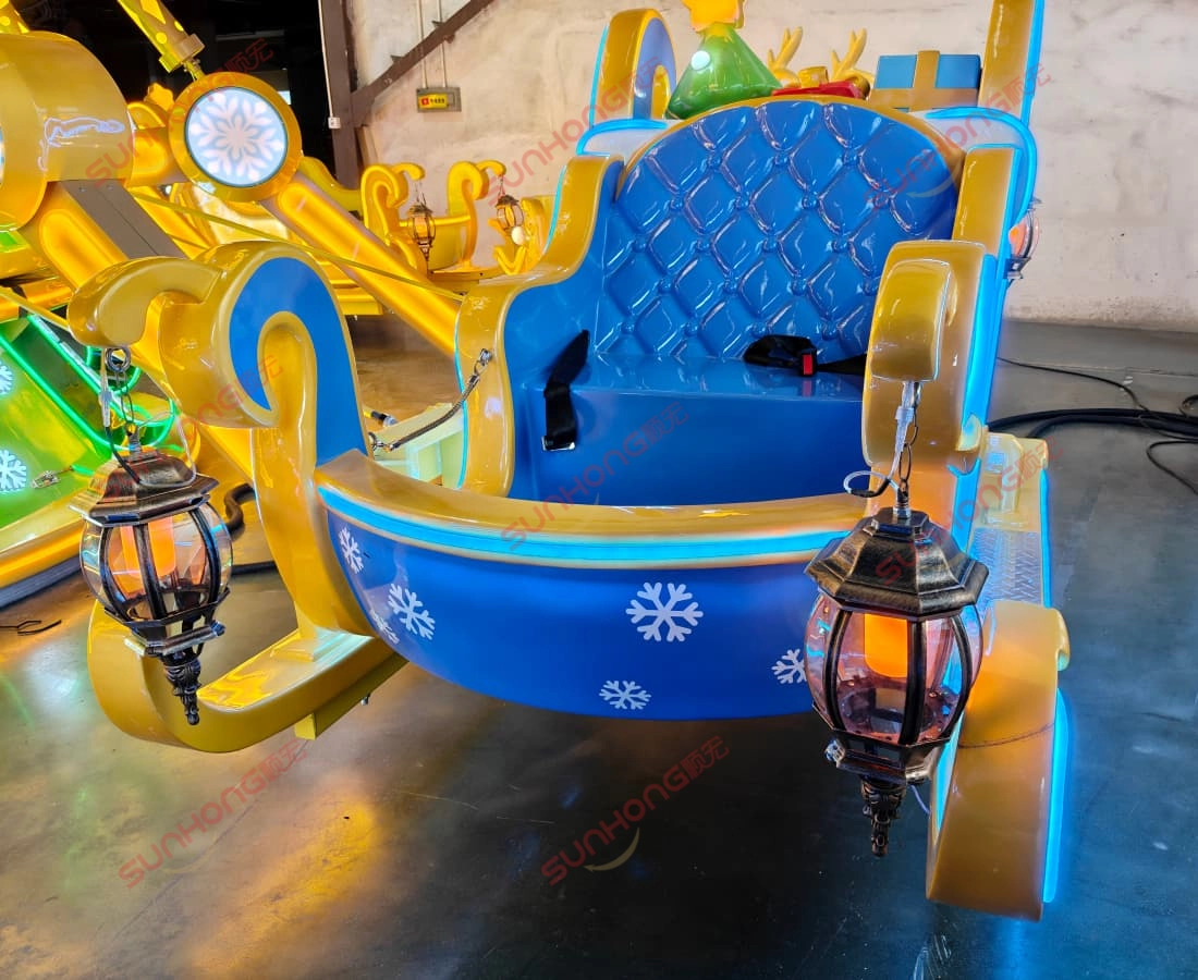 blue-yellow-sleigh-amusement-ride-snowflake-lanterns.jpg - SUNHONG Blue and yellow amusement park sleigh ride decorated with lantern-style lights and snowflake decals. - SUNHONG