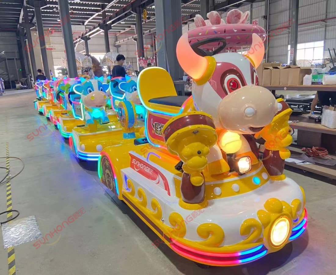 bull-train-production-lineup-small-trains-for-parks - SUNHONG Bull Train units lined up with lights on in factory workshop, small amusement trains for park rides - SUNHONG