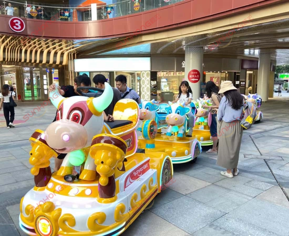 bull-train-riding-experience-outdoor - SUNHONG Families and kids riding the bull-themed electric train in an outdoor shopping mall setting, popular small trains for parks - SUNHONG