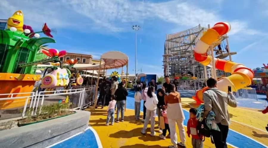 Parque de diversões com tema de floresta mágica, apresentando o SUNHONG Larva Blooms à esquerda e um playground coberto à direita - SUNHONG