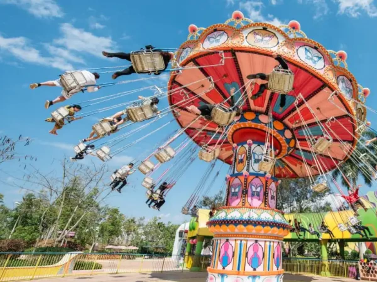 Vintage chair swing ride in a theme park, decorated with butterfly motifs.