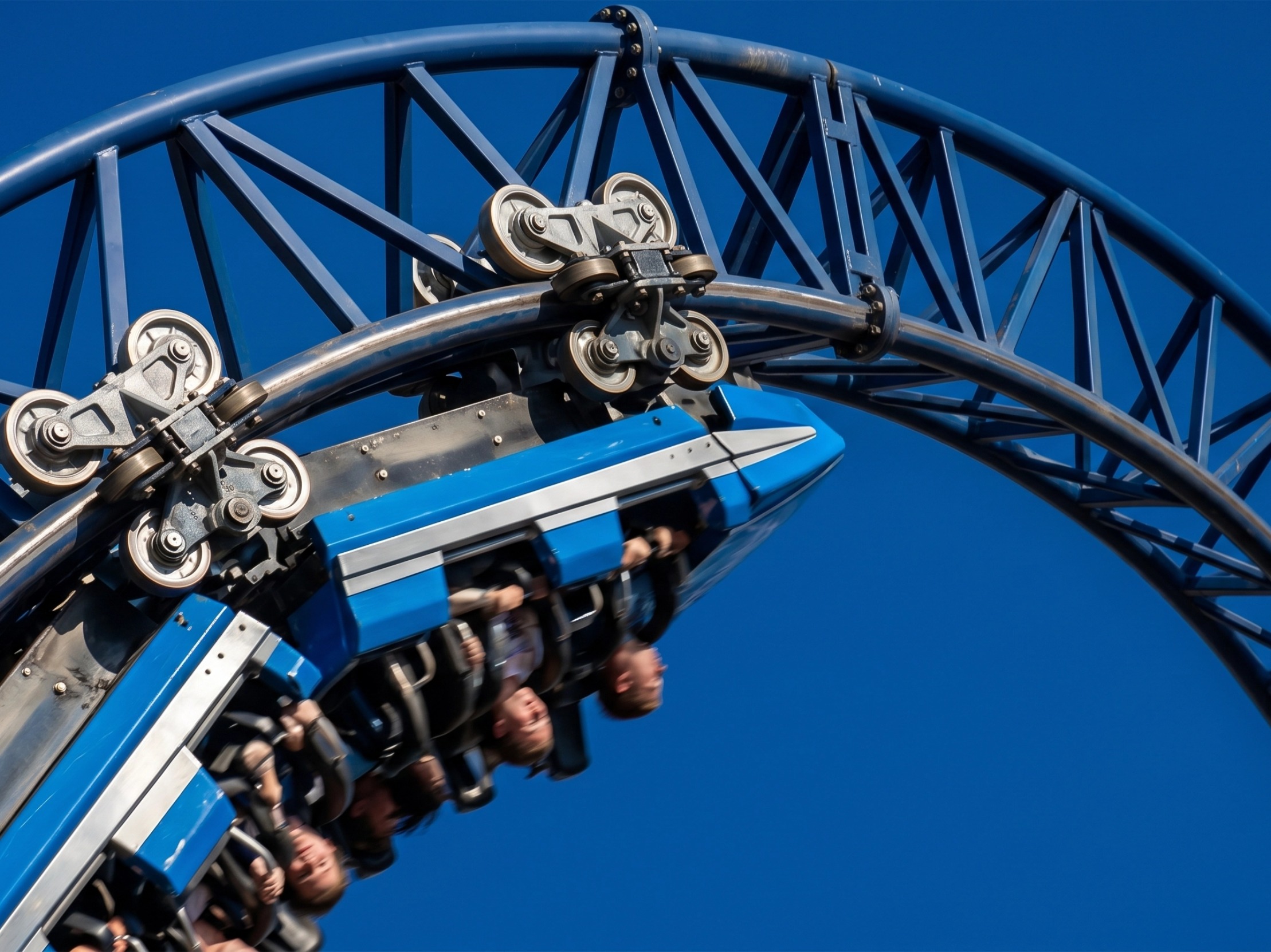 Close-up of a modern steel roller coaster train speeding through a vertical loop