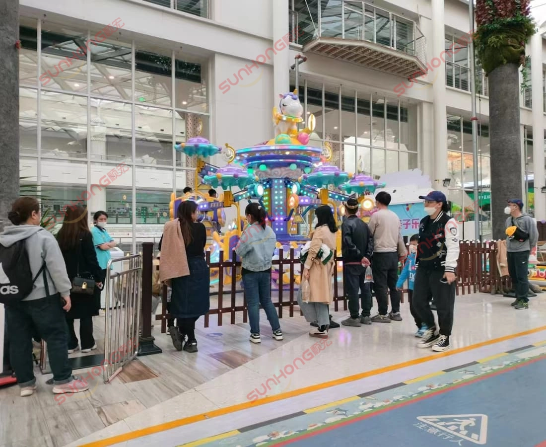 fairy-unicorn-ride-indoor-mall-queue - SUNHONG Families lining up to ride the Fairy Unicorn attraction inside a shopping mall, showing indoor deployment adaptability. - SUNHONG