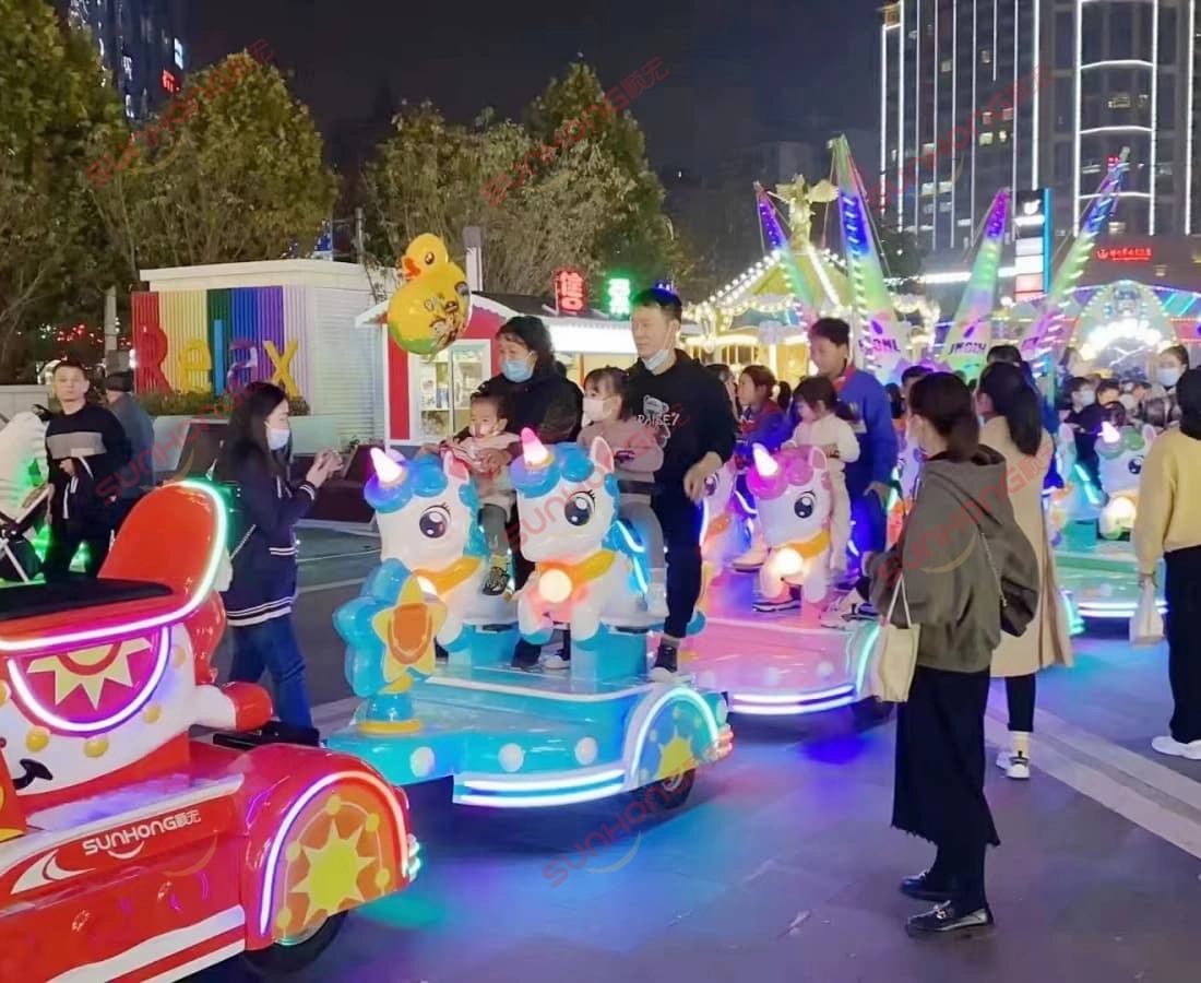 family-kiddie-train-ride-unicorn-outdoor-night - SUNHONG Perjalanan kereta api unicorn mesra keluarga berjalan di luar rumah pada waktu malam dengan kanak-kanak gembira di atas kapal. - SUNHONG