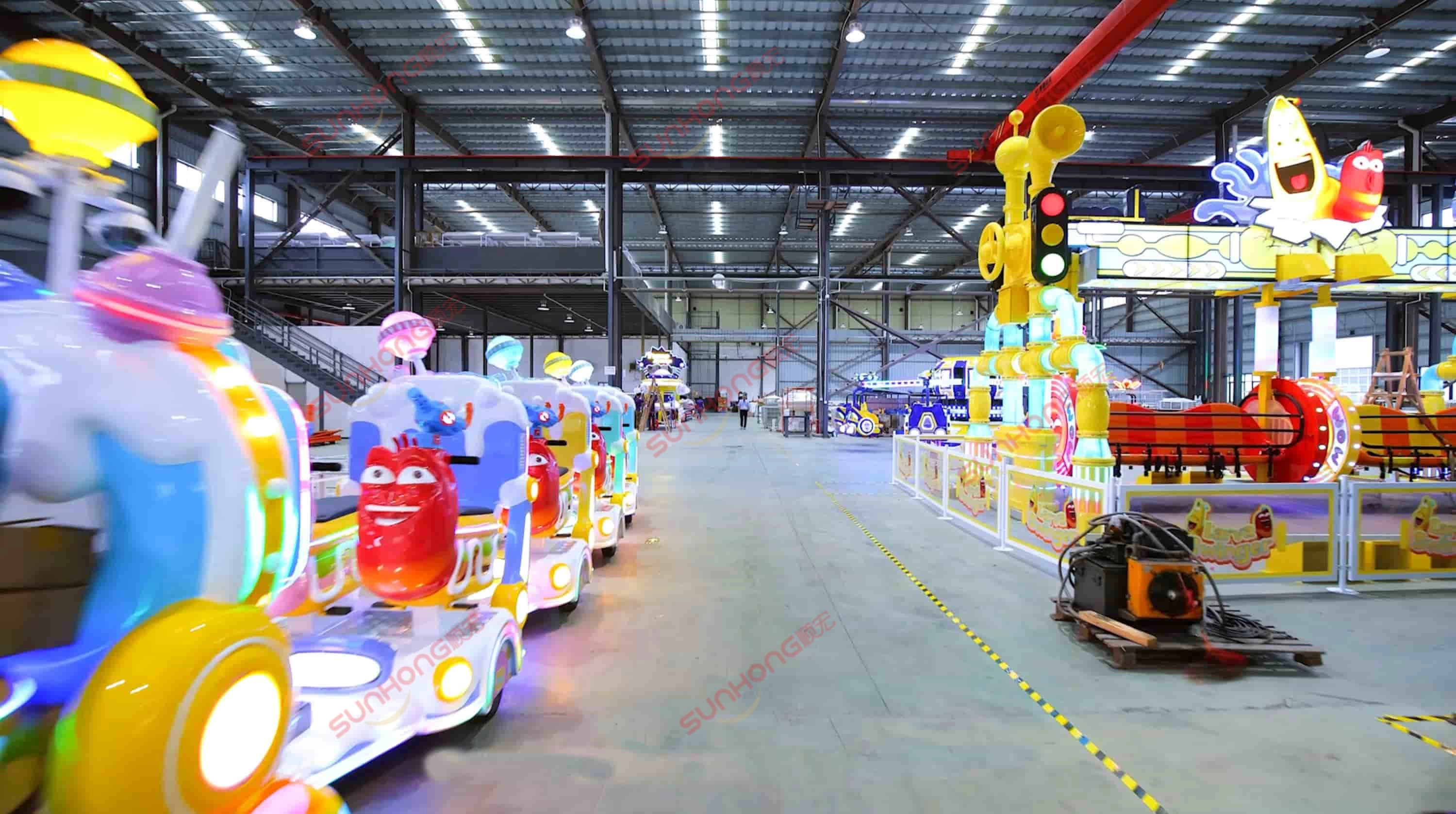 indoor-family-ride-assembly-line - SUNHONG Colorful family amusement rides being assembled and tested in a clean, modern indoor workshop of a leading ride manufacturer. - SUNHONG