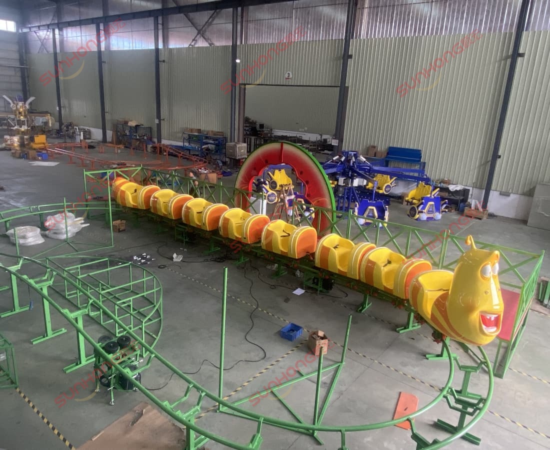 Installation components for the pineapple-shaped gate of Larva Fruitland mini roller coaster. Initial assembly view of Larva Fruitland mini coaster at SUNHONG’s production workshop.