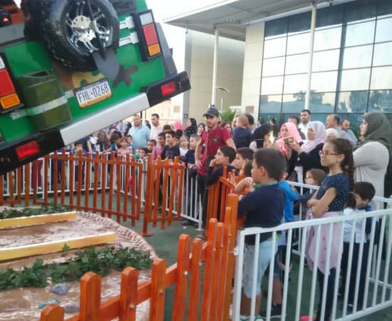 ألعاب أطفال للبيع - لعبة Jurassic Swinger الدوارة الترفيهية، مع العديد من الأطفال ينتظرون في طوابير لتجربة هذه اللعبة الممتعة للأطفال أثناء تشغيلها. - SUNHONG