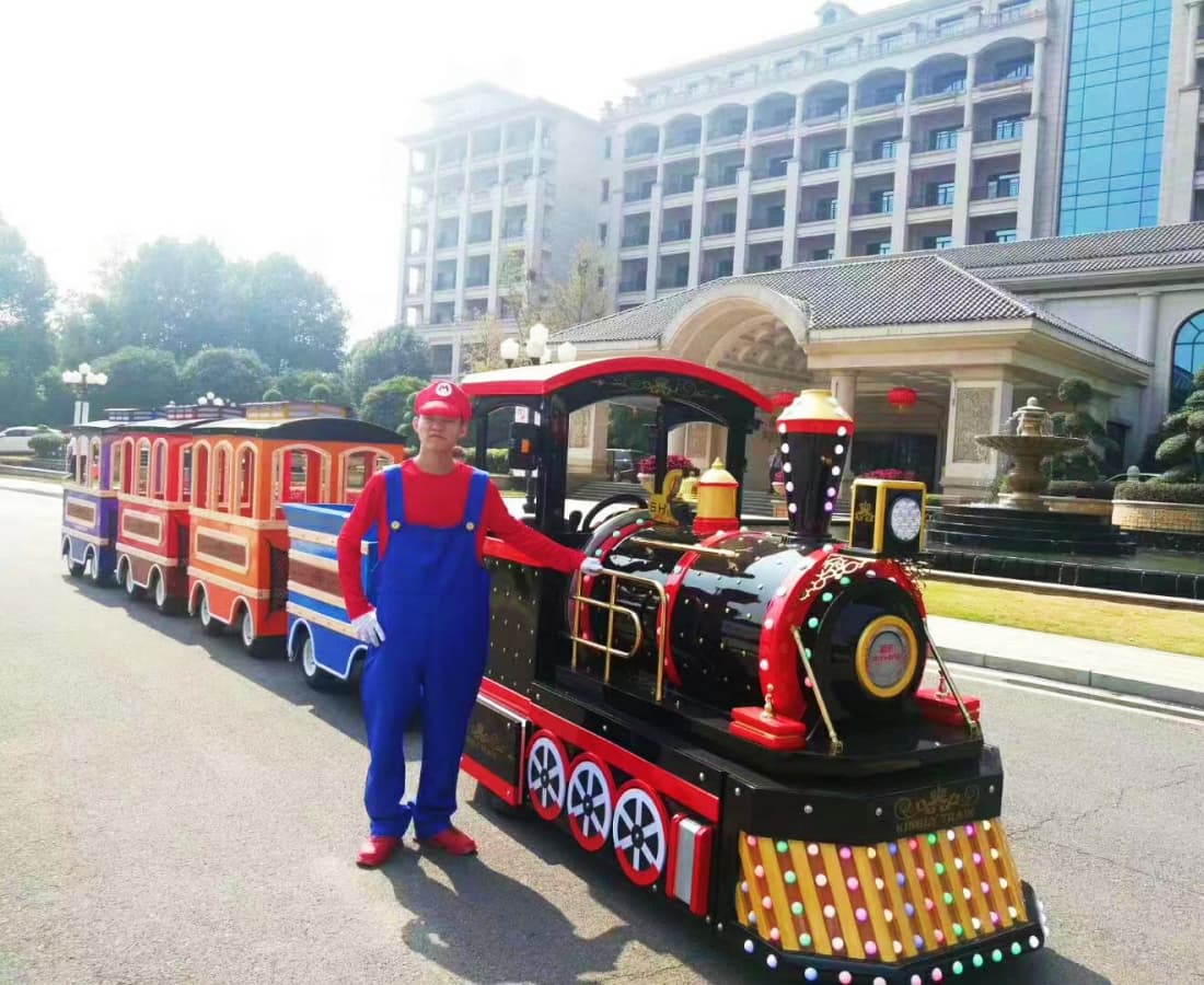 Tren real sin vías exhibido con personaje de mascota frente al hotel, tren eléctrico en venta - SUNHONG