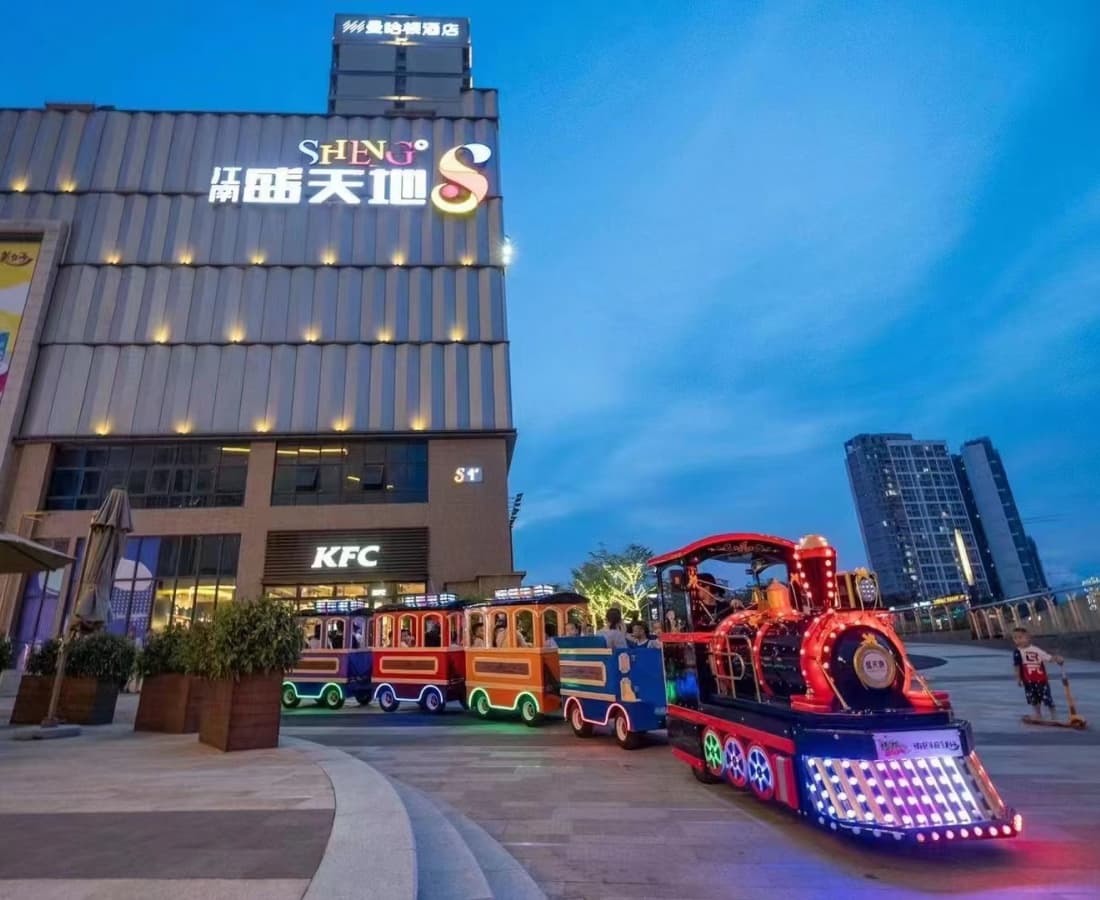 Tren real sin vías con luces LED funcionando de noche cerca de un centro comercial, tren real eléctrico sin vías para eventos - SUNHONG