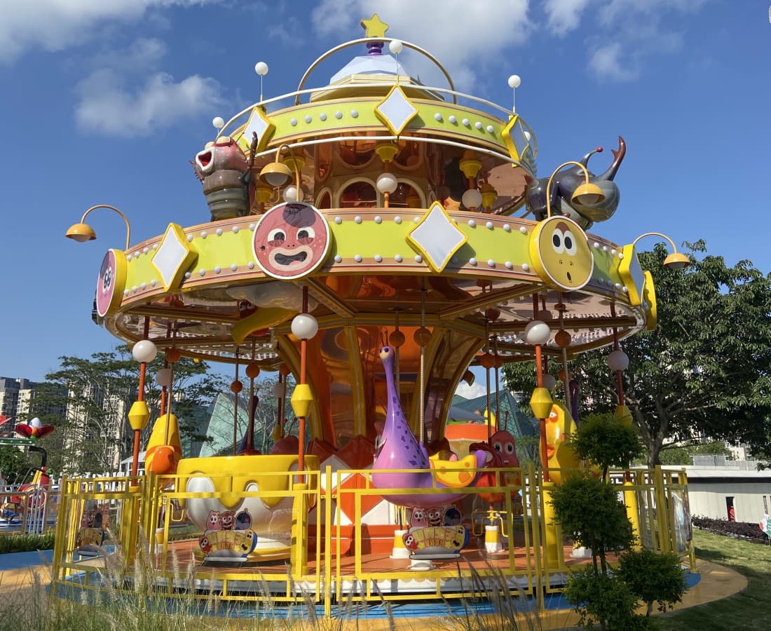 Carrossel de larvas coloridas em um parque, com personagens e detalhes em amarelo brilhante. - SUNHONG