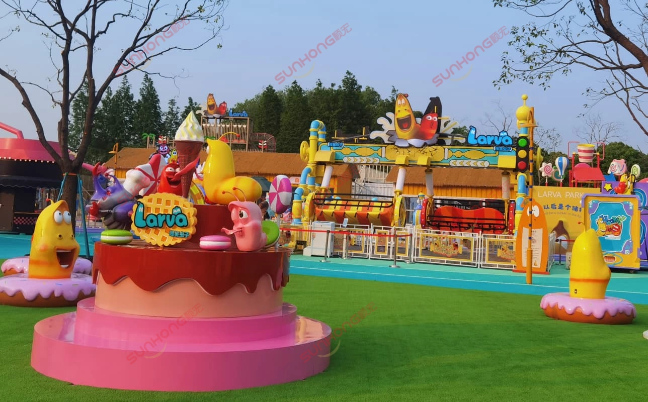 Larva-Cupcake-Yellow-Red-Swing-Ride-Background - SUNHONG Larva-themed cupcake featuring Yellow and Red, with the Larva Swing ride in the background. - SUNHONG