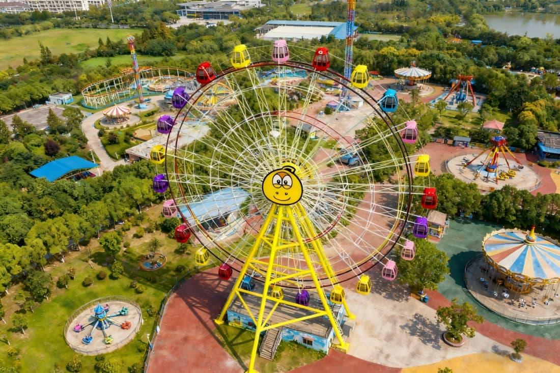 Amusement park aerial view with a Ferris wheel flat ride.