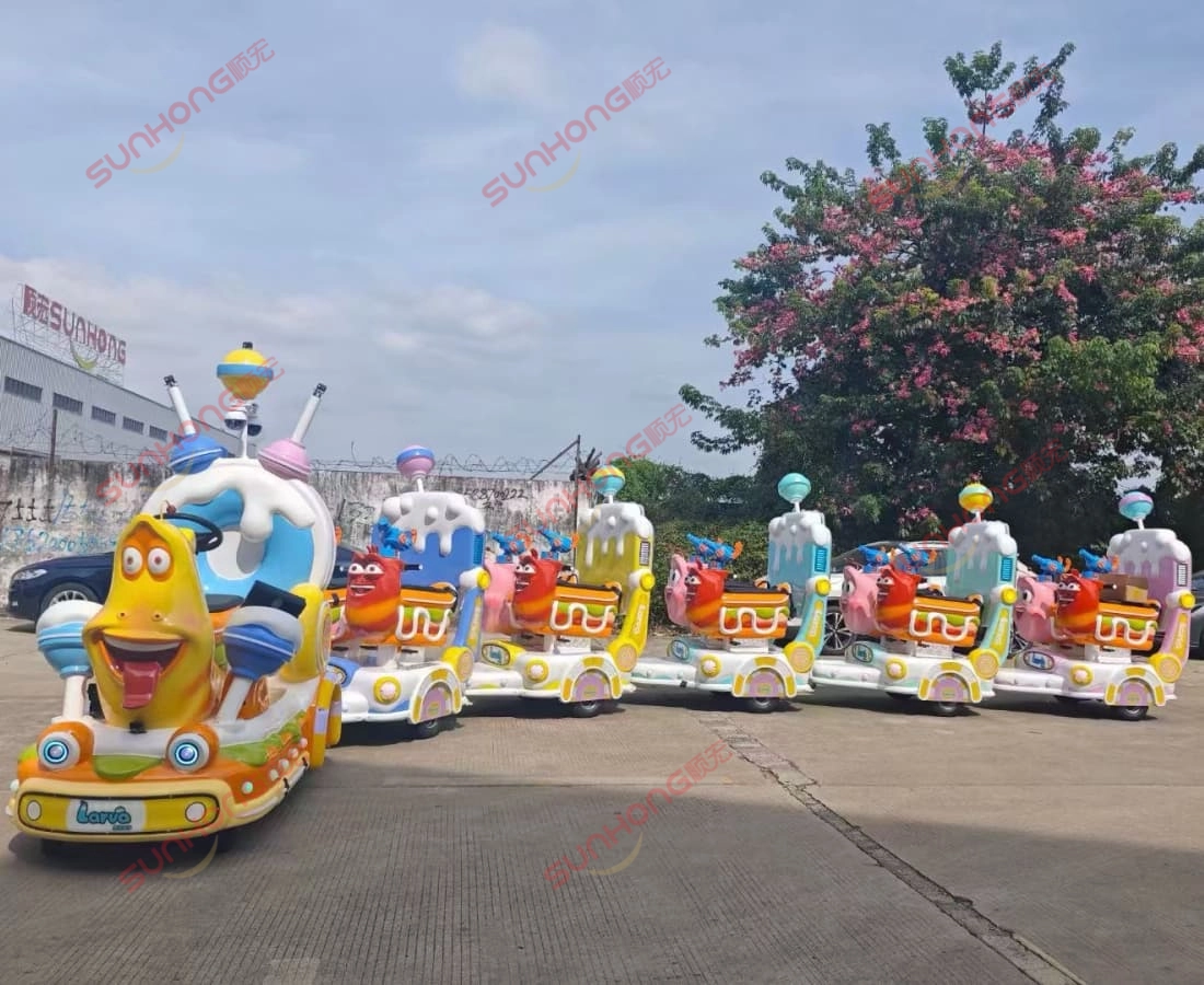 幼虫游侠无轨小火车-孙宏-工厂正面-黄红色 - 孙宏 出售的 Larva Ranger 无轨火车摆放在 SUNHONG 工厂前,以黄色和红色字符为特色,背景为 SUNHONG 徽标。 - SUNHONG