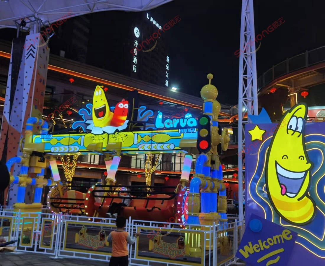 larva-swing-ride-for-sale-night-glowing-yellow-crowd - SUNHONG Larva Swing ride for sale with glowing Yellow character and many riders at night. - SUNHONG