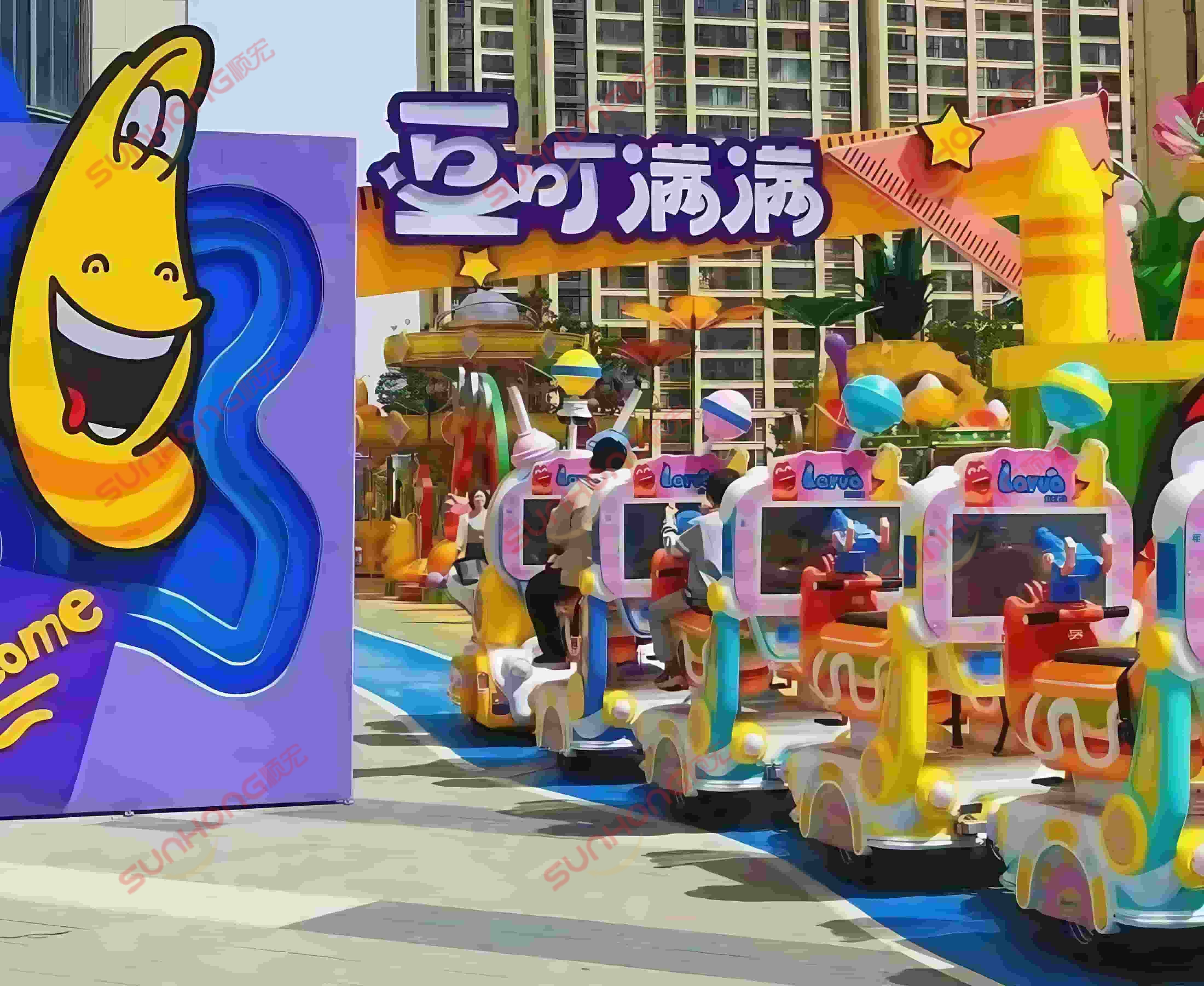 larva-train-passing-through-theme-park-gate Larva Ranger trackless train ride enters a themed park gate inspired by the Larva cartoon — colorful attraction available for sale.