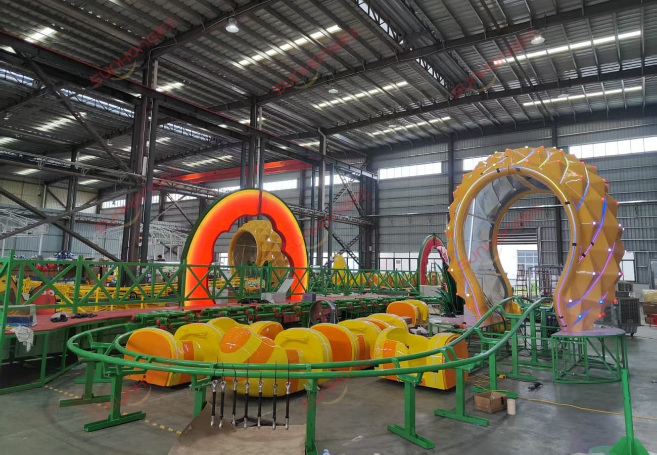 Mini Roller Coater in SUNHONG Factory Indoor view of a yellow and orange mini roller coaster.