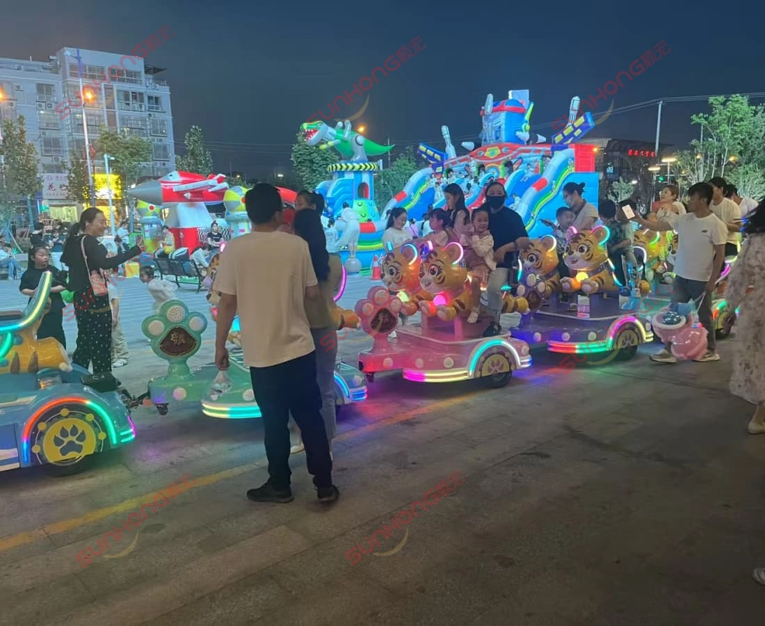 night-event-tigger-trackless-train-ride-for-kids - SUNHONG Tigger-themed kiddie train rides in use at a colorful night carnival, surrounded by happy children. - SUNHONG