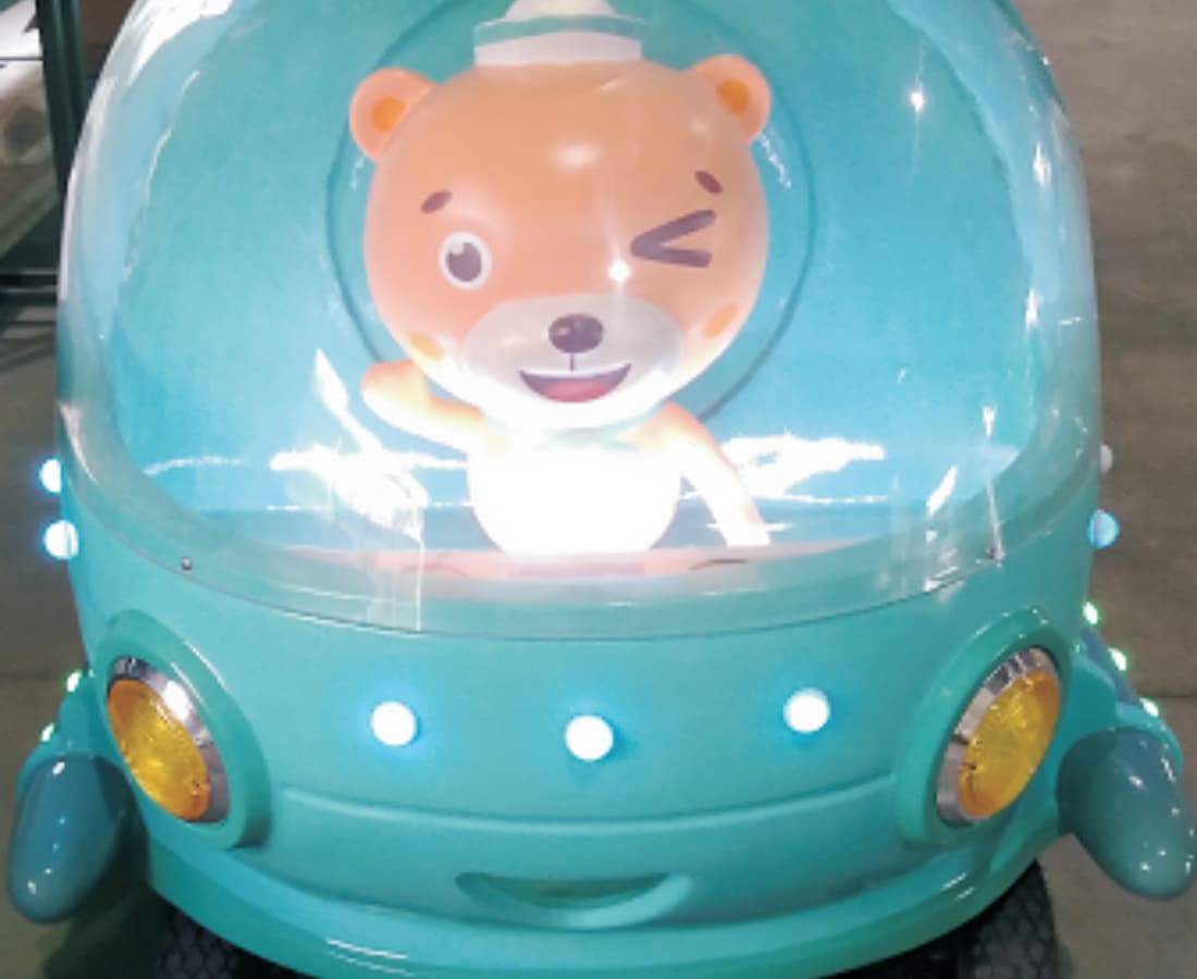 Vista frontal do trem elétrico sem trilhos Ocean Train com um personagem de desenho animado urso e faróis de LED. - SUNHONG