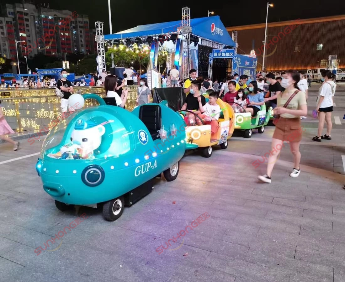 octonauts-13p-trem-sem-trilhos-operação-noturna - SUNHONG Visão noturna dos vagões de trem sem trilhos Octonauts 13P à venda em operação em uma praça pública movimentada, popular entre famílias e crianças. - SUNHONG