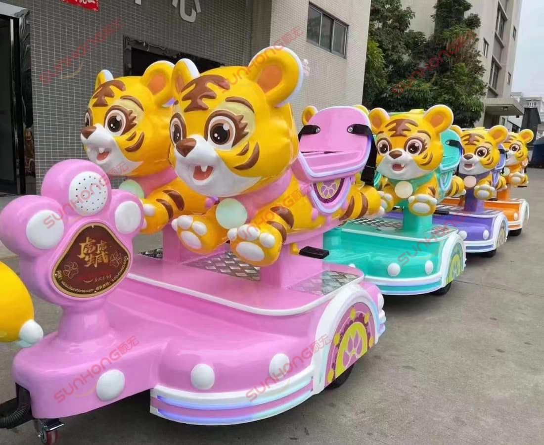 pink-tigger-trackless-small-train-rides-for-kids - SUNHONG Adorable pink Tigger kiddie train rides in front of amusement equipment factory, ready for delivery. - SUNHONG