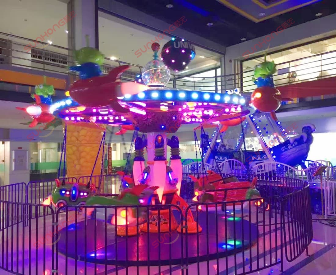 space-hovering-flying-chairs-kids-ride.jpg Aerial view of SUNHONG amusement ride manufacturing factory with Larva logo, surrounded by green fields and nearby residential area.