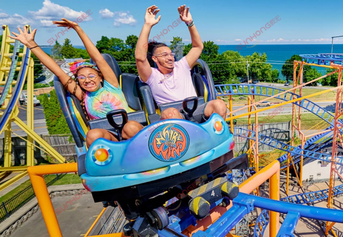 spinning-coaster-riders-hands-up - SUNHONG Two people riding a spinning coaster with hands up and big smiles - SUNHONG