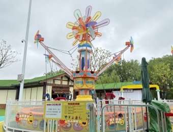 Brinquedo colorido de parque de diversões: trampolim com braços giratórios e decorações em forma de hélice. - SUNHONG