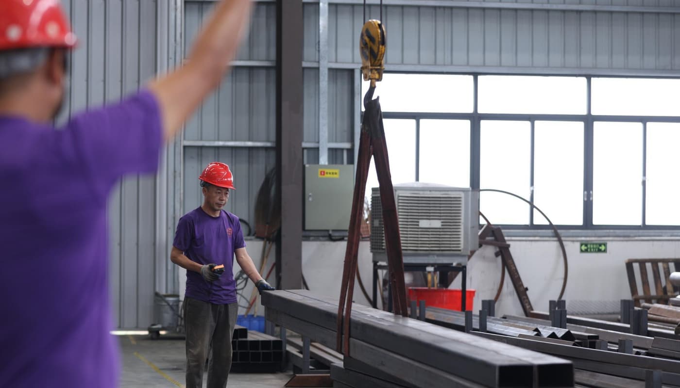 Un ouvrier de l&#39;usine SUNHONG assemble des matériaux de structure en acier, montrant la première étape de la construction d&#39;un train sans rails