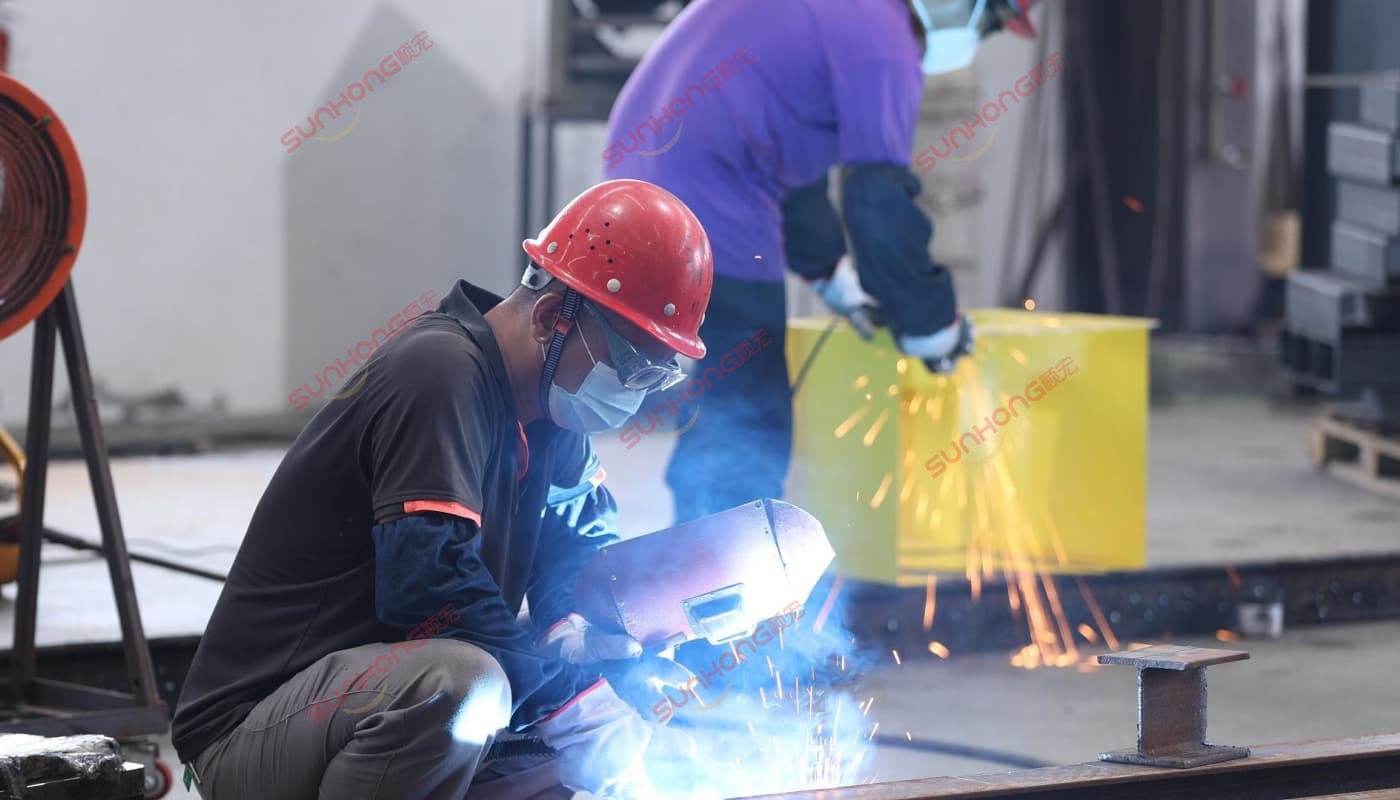 sunhong-welding-process Welding sparks during chassis construction at SUNHONG factory – key step in how to make a trackless train frame