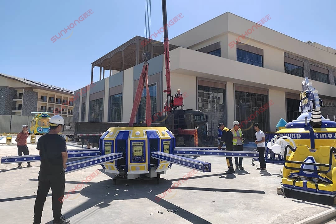 Trabalhadores da SUNHONG instalando o brinquedo Time Jump ao ar livre usando um guindaste Trabalhadores da SUNHONG instalando o Time Jump Ride ao ar livre usando um guindaste
