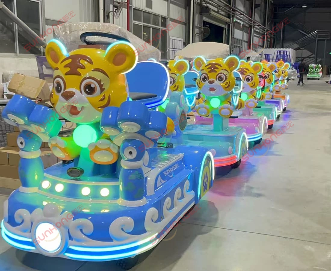 tigger-trackless-small-train-rides-warehouse-light - SUNHONG Line of illuminated Tigger trackless small train rides inside factory ready for shipment. - SUNHONG