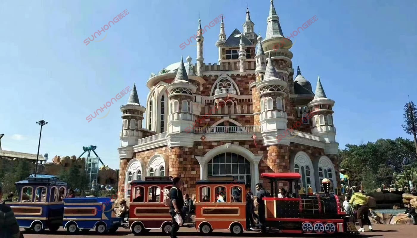 trackless-train-castle-scene Kingly Trackless Train operating in front of a castle in a theme park – completed trackless train in operation