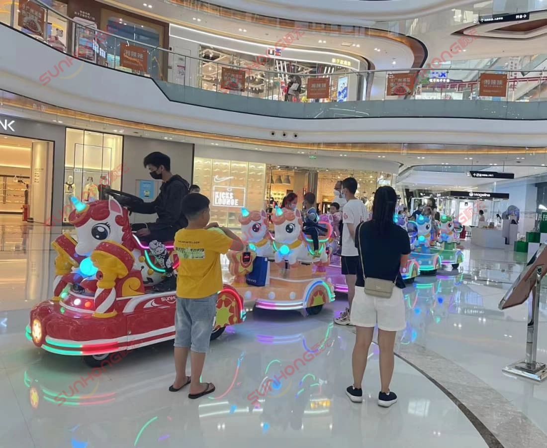 unicorn-kiddie-train-ride-mall-center-daytime - SUNHONG Tarikan menaiki kereta api unicorn tertutup dengan kanak-kanak dan orang dewasa di pusat beli-belah pada waktu siang. - SUNHONG