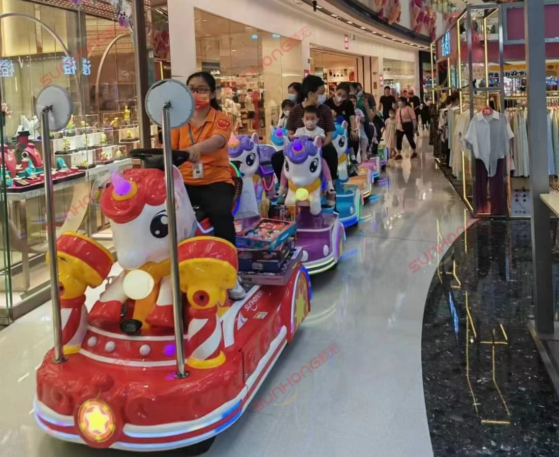 unicorn-kiddie-train-rides-shopping-mall-crowd - SUNHONG Perjalanan kereta api kanak-kanak unicorn panjang yang beroperasi di pusat beli-belah yang sesak, dipandu oleh kakitangan dan membawa kanak-kanak. - SUNHONG