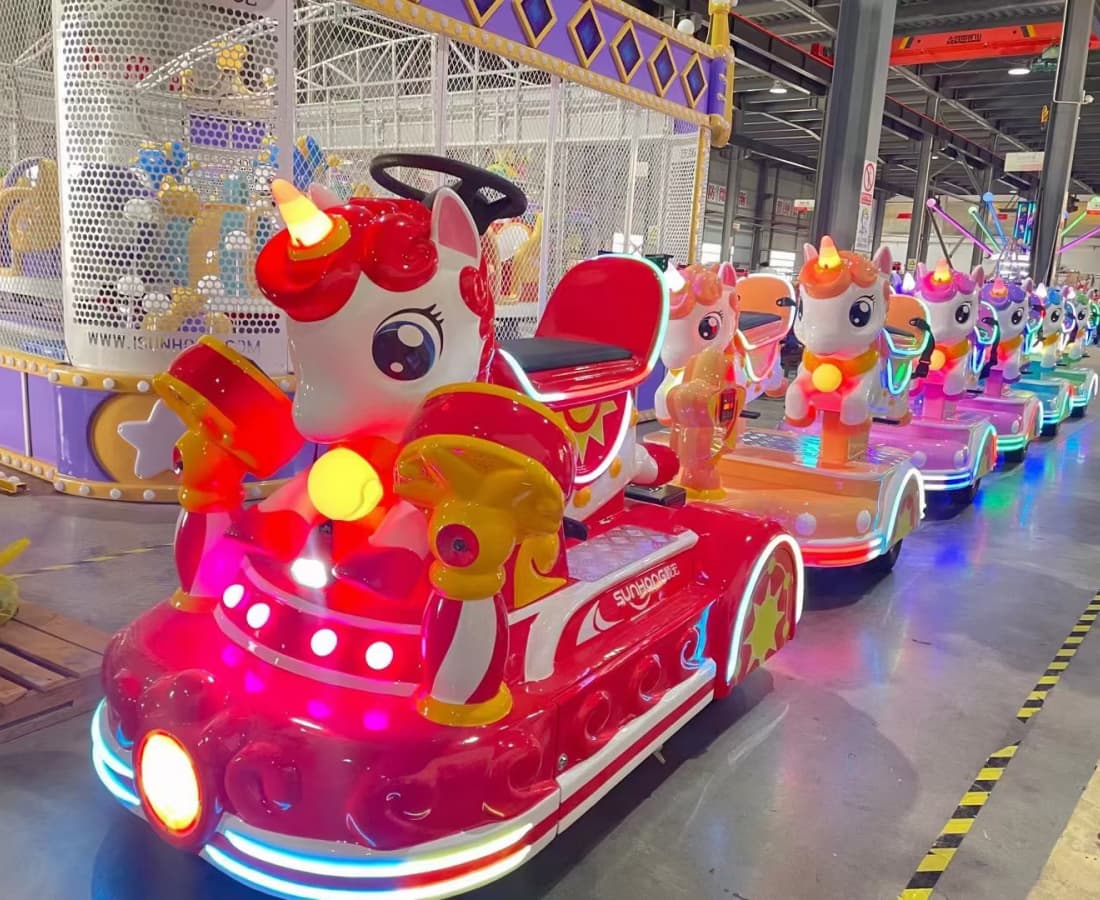 قطار أطفال ملون على شكل وحيد القرن في بيئة مصنع، مصمم لمتعة الأطفال والعائلة - سونهونغ