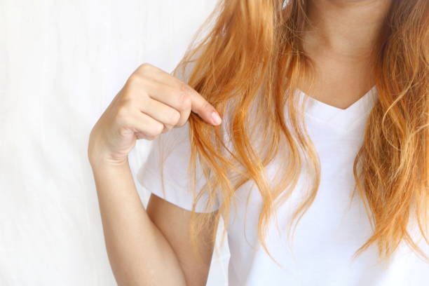 Repair damaged hair: Woman points to split ends.