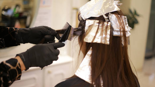 Salon hair treatment products being applied to a client's hair.