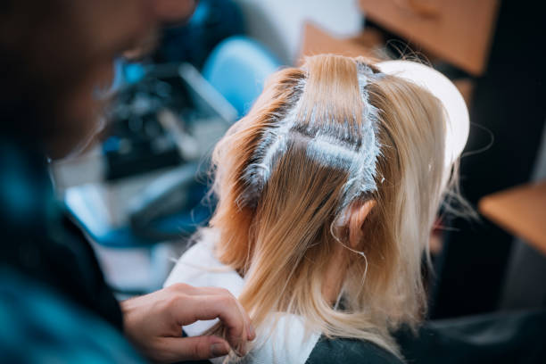 Woman receiving hair protein treatment products.