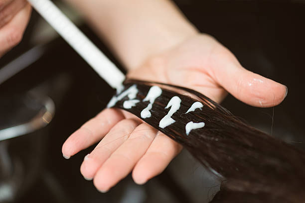 applying cream to damaged hair.