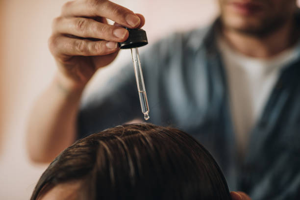 Close-up of wholesale hair oil being applied to scalp.