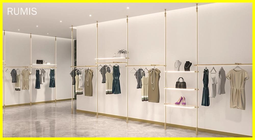 Elegante sistema modular de exposição de varejo dourado exibindo roupas e acessórios femininos.