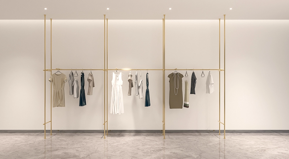 Elegant gold EOS shopfitting display systems showcasing apparel on a clean, minimalist backdrop.