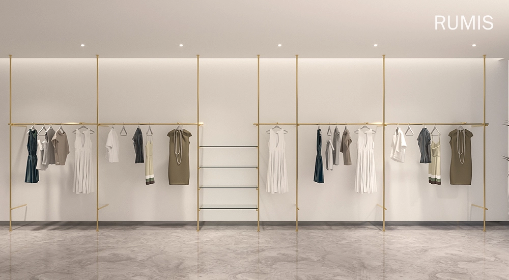 FLEX FLEEK custom retail clothing displays: Elegant gold clothing racks showcasing apparel in a modern retail space.